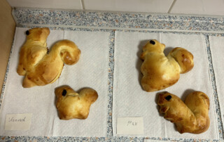 Verschiedene Hefegebäcke in Tier- und Fantasieformen auf einer Arbeitsfläche.