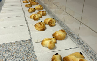Reihe von gebackenen Hefeteigfiguren, sortiert auf Papiertüchern.