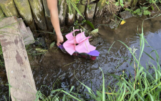 Kleine gebastelte Boote aus Kork und Papiersegeln liegen schwimmend in einer Schüssel.