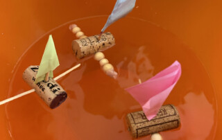 Ausstellung von gebastelten Booten in einem Glasvitrinenschrank.