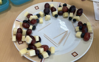 Obstspieße auf einem Teller, arrangiert in Kreisform.