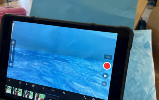 Tablet steht vor einer gebastelten Kulisse und zeigt eine Aufnahmeszene für einen Stop-Motion-Film.