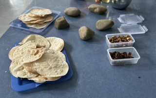 Auswahl verschiedener Lebensmittel wie Fladenbrot, Bohnen und Datteln auf einem Tisch angeordnet.