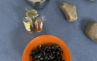Schale mit schwarzen Bohnen neben weiteren kleinen Schalen mit Zutaten auf einem Tisch.