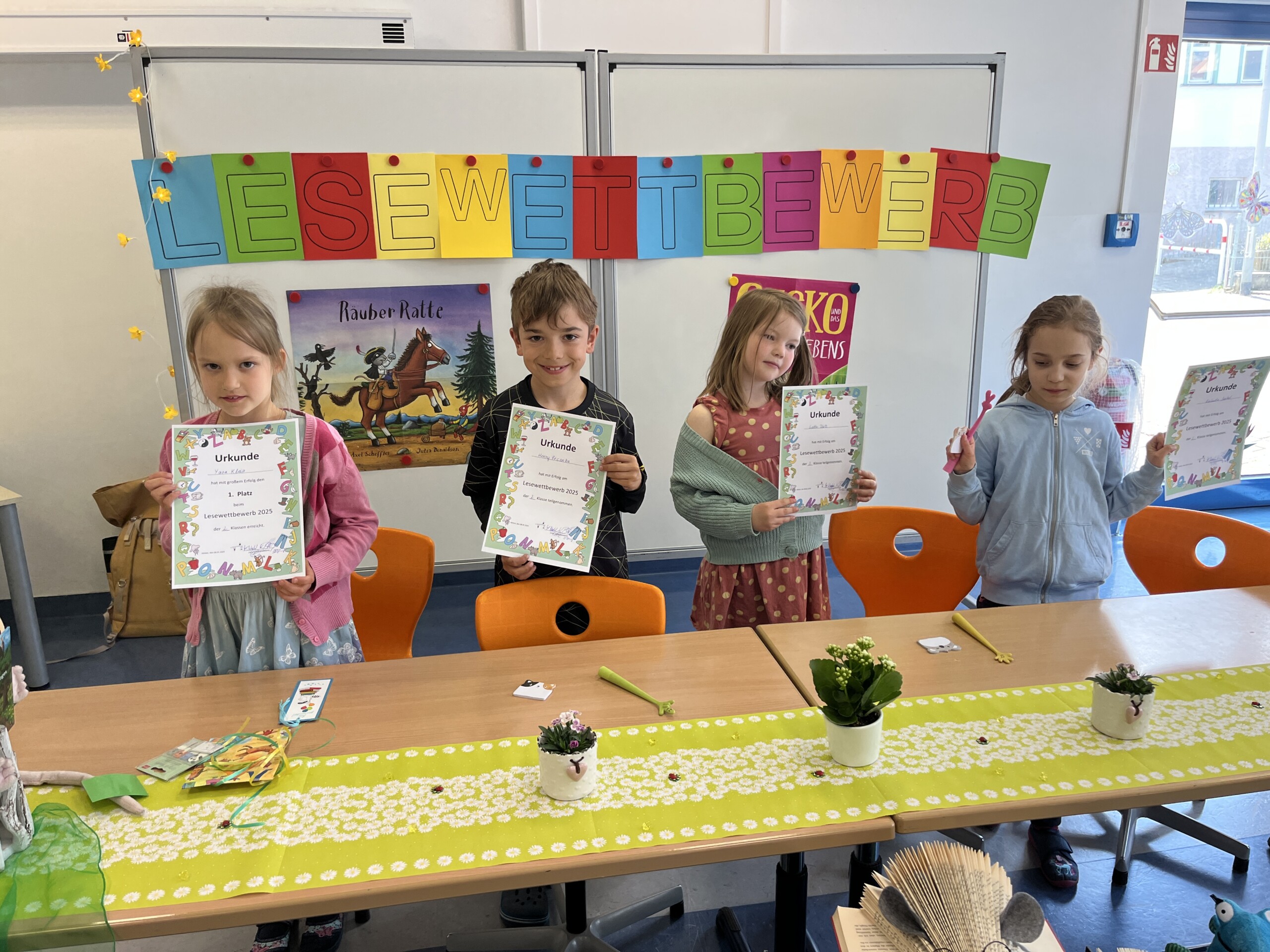 Mehrere Kinder stehen nebeneinander und zeigen ihre gebastelten Blätter.