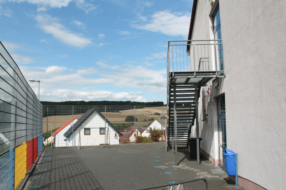 Hinterhof mit Metalltreppe und Blick über die umliegenden Häuser.