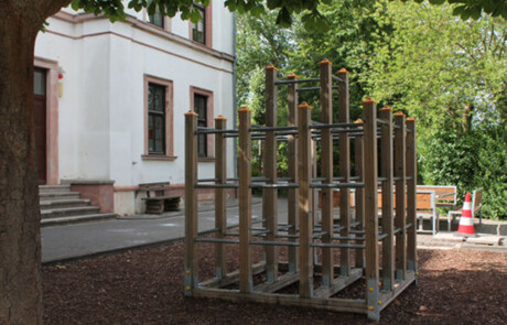 Schulgebäude_02 Außenaufnahme der Alteburgschule Heftrich mit Klettergerüst im Vordergrund.