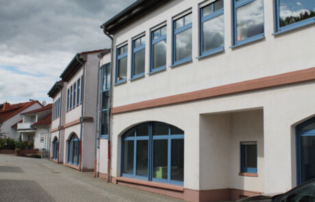 Schulgebäude_09 Moderne Glasfront eines Schulgebäudeteils mit blauem Rahmen.