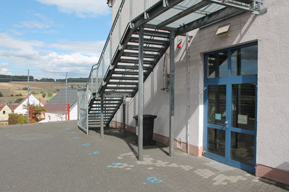 Metalltreppe und Eingang an der Rückseite eines Schulgebäudes.