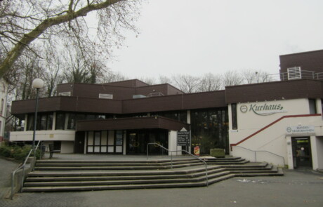 Außenansicht Gebäude Außenansicht eines Schulgebäudes mit Treppe und überdachtem Eingangsbereich an einem bewölkten Tag