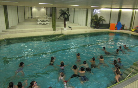 Schwimmkurs / Gruppe im Wasser Gruppe von Kindern im Wasser in einem Hallenbad während einer Schwimmstunde.