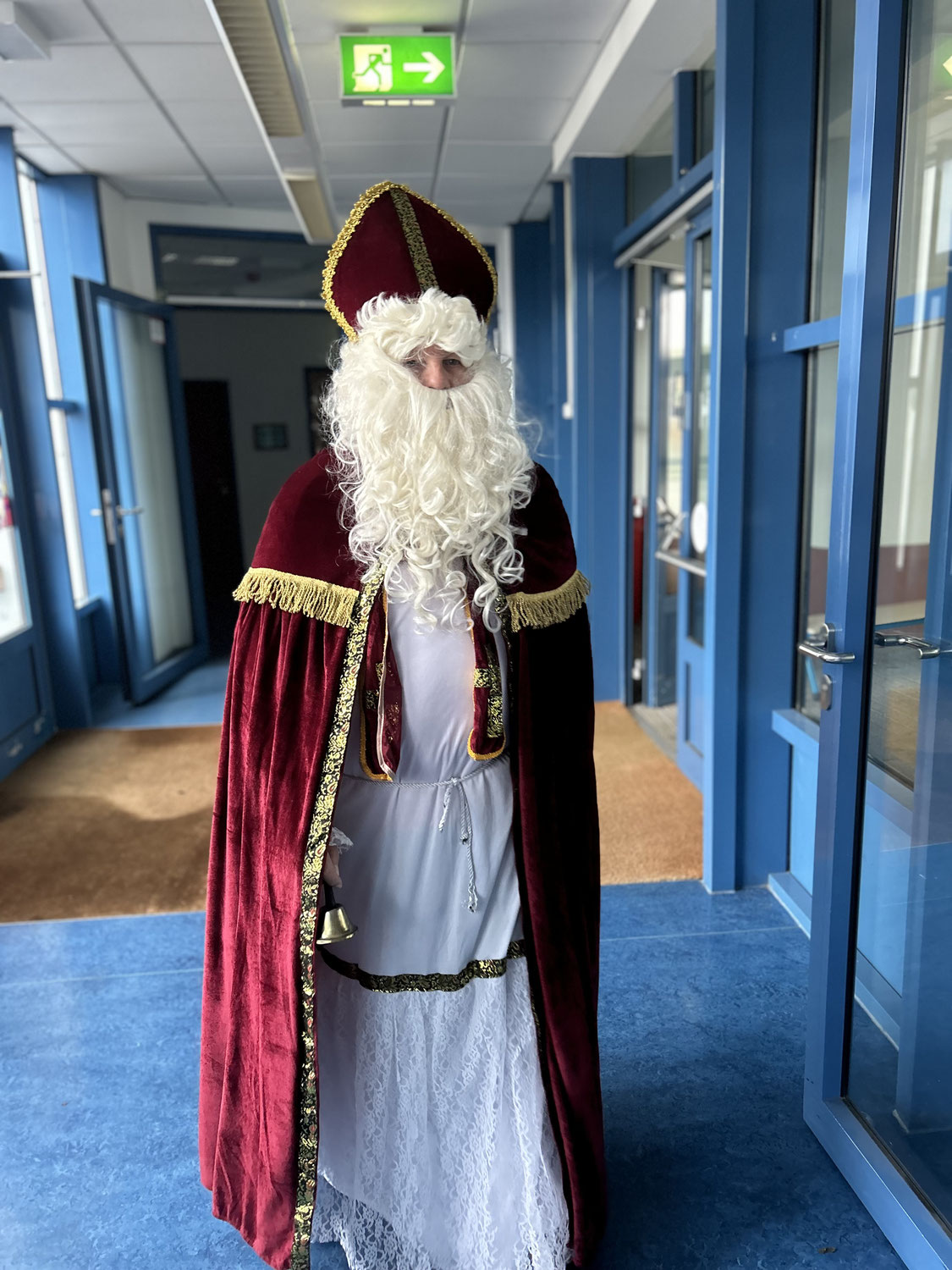 Nikolaus im Schulgebäude Eine als Nikolaus verkleidete Person mit rotem Mantel und weißem Bart steht im Flur eines Schulgebäudes.