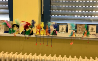 Mehrere Kinder stehen im Freien vor einer Hauswand und schauen nach vorn.